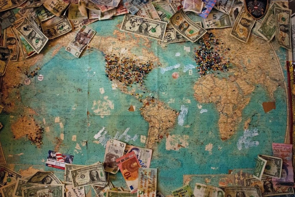 Mapa mundi coberto por dinheiro. ilustrando a importância da economia global e de investir no exterior.